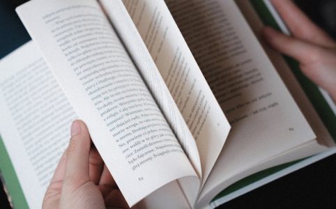 hands flipping pages of an open book