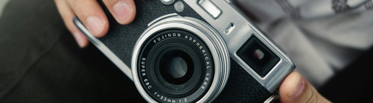 close up of hands holding a fujifilm camera