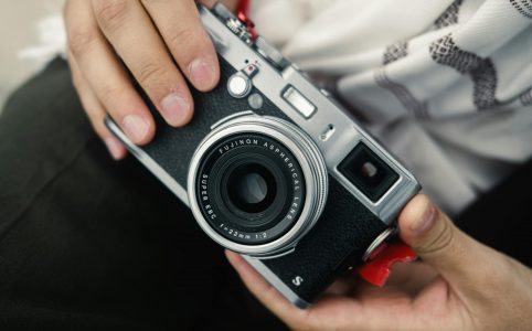 close up of hands holding a fujifilm camera