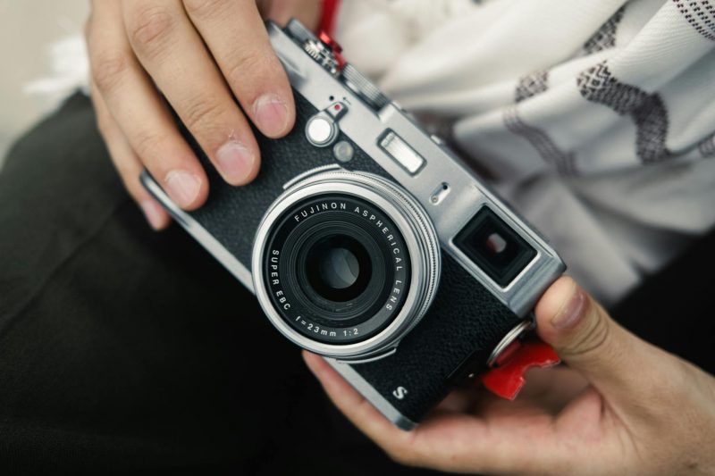 close up of hands holding a fujifilm camera